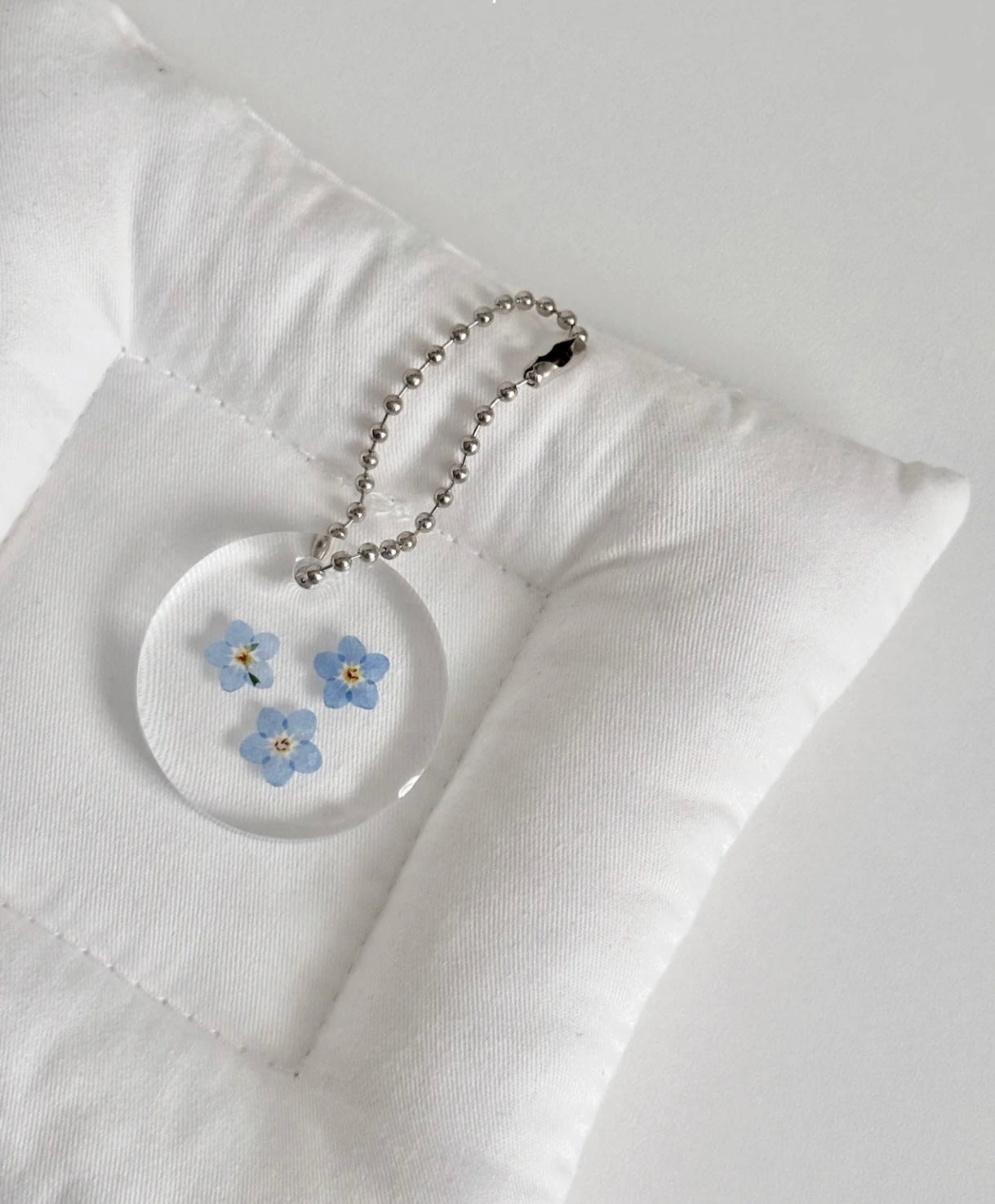 Forget-Me-Not resin accessory used as bag charm or memory token