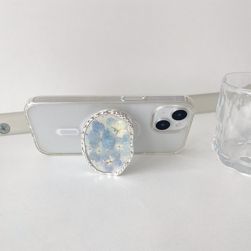 Floral resin phone grip used as stand on smartphone